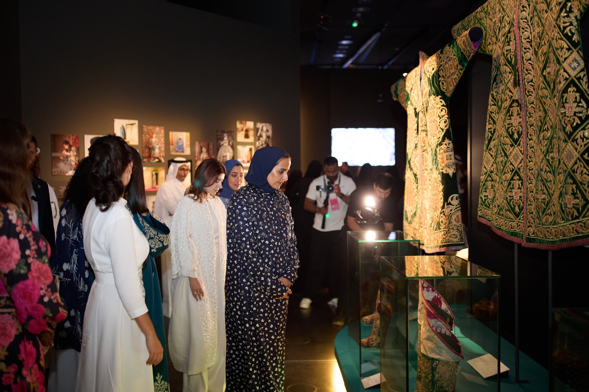 Visitors viewing large embroidered Uzbek garments in a darkened gallery at the Museum of Islamic Art in Doha